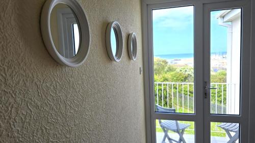 a room with three mirrors on the wall next to a door at Fairlee in Perranporth