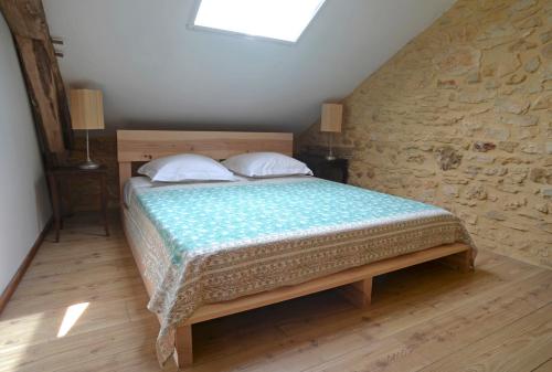 a bedroom with a bed with two pillows at Grange avec piscine - La Hulotte du Cluzel in Montcléra