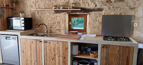 a kitchen with a sink and a counter top at Grange avec piscine - La Hulotte du Cluzel in Montcléra