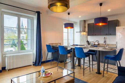 - une cuisine avec des chaises bleues et une grande île dans la chambre dans l'établissement - L'instant Loire - Vue sur la Loire, à Blois