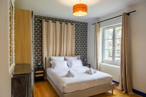 une chambre avec un lit blanc et une fenêtre dans l'établissement - L'instant Loire - Vue sur la Loire, à Blois