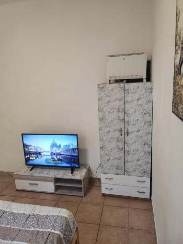 un salon avec une télévision à écran plat assise sur une armoire dans l'établissement Pratique, à Sète