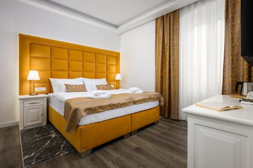 ein Schlafzimmer mit einem großen Bett mit einem gelben Kopfteil in der Unterkunft Boutique Hotel Golden Key - Poreč - Bed & Breakfast in Poreč