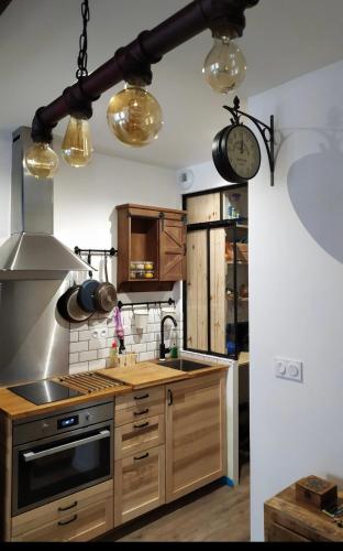 une cuisine avec des armoires en bois et une horloge au mur dans l'établissement Carré des Halles, à Bayonne