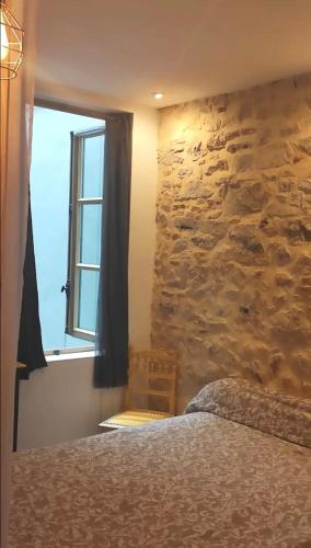 une chambre avec un mur en pierre et un lit dans l'établissement Carré des Halles, à Bayonne