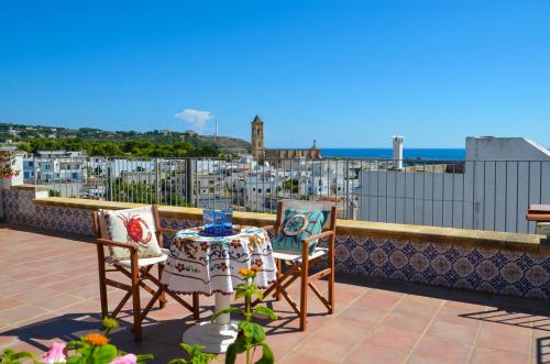 Ein Tisch und Stühle auf einem Balkon mit Blick auf die Stadt in der Unterkunft Casa dell'Ospite in Santa Maria di Leuca