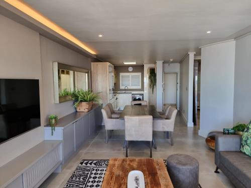 a living room with a table and a couch at Lagoon Shoreline 2 Bedroom Apartment in Cape Town