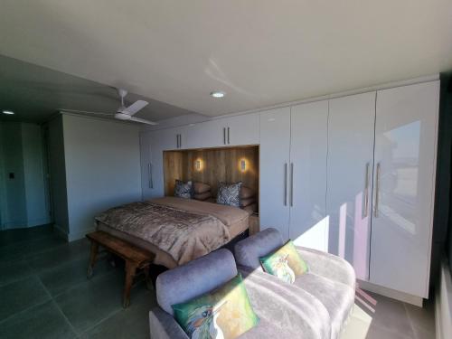 a bedroom with a bed and a couch at Lagoon Shoreline 2 Bedroom Apartment in Cape Town