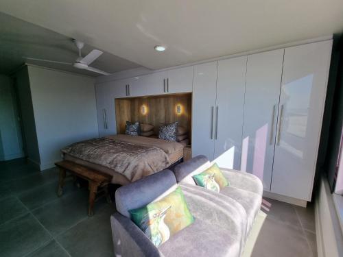 a bedroom with a bed and a couch in it at Lagoon Shoreline 2 Bedroom Apartment in Cape Town