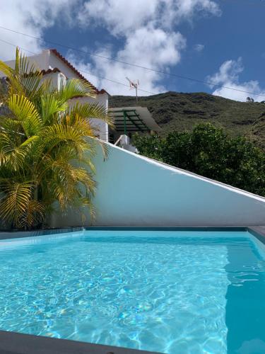 a swimming pool in front of a house at El Paraíso Agaete Valle in Agaete