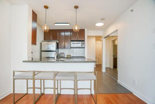 a kitchen with two bar stools and a counter at Executive Unit with Spectacular Views in Vancouver