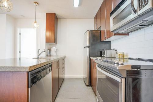 a kitchen with stainless steel appliances and wooden cabinets at Executive Unit with Spectacular Views in Vancouver