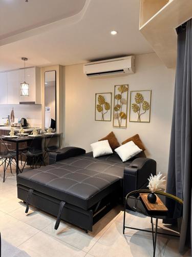 a living room with a black bed and a kitchen at Tambuli Blue Premium Seaview in Lapu Lapu City