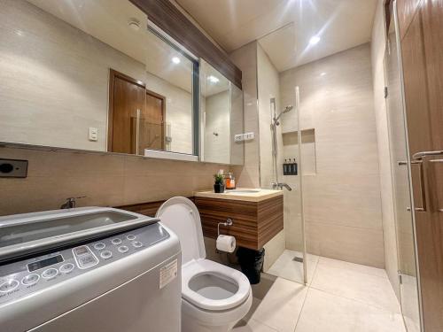 a bathroom with a toilet and a sink and a shower at Tambuli Blue Premium Seaview in Lapu Lapu City