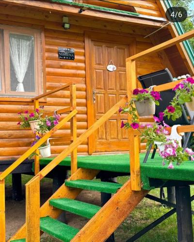 a log cabin with flowers on the stairs at Vikendica Mimiena in Račić