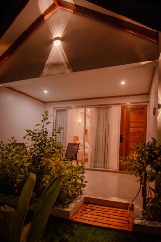 a living room with plants in front of a house at Handhuvaru Maldives in Milandu