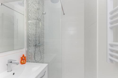 une salle de bain blanche avec une douche et un lavabo dans l'établissement Brocéliande, à Brest