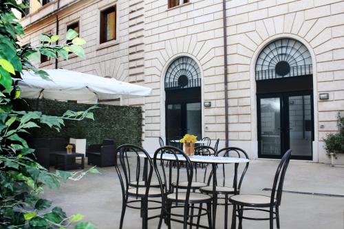 a patio with chairs and a table in front of a building at Roma Resort Termini in Rome