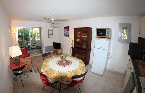 un salon avec une table et une cuisine dans l'établissement T2 climatisé à 500m de la plage sur la presqu'ile de Saint Mandrier sur Mer, à Saint-Mandrier-sur-Mer