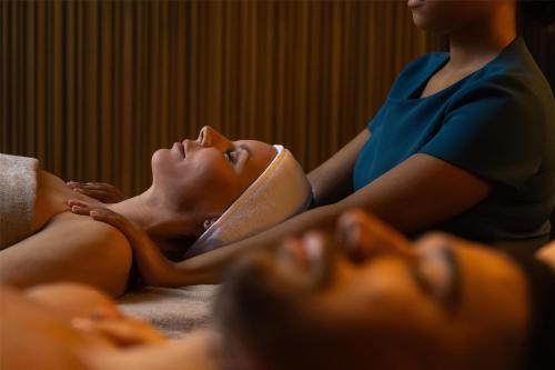 a woman laying on a bed with her eyes closed at art'otel London Hoxton in London
