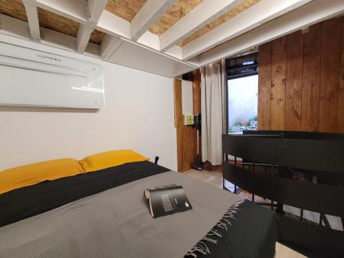 - une chambre avec un lit doté de draps jaunes et une fenêtre dans l'établissement Appartement Sillans la cascade village historique, à Sillans-la-Cascade