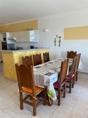 a dining room with a table and chairs and a kitchen at GRANDE VILLA TIZZANO A 200 M DE LA PLAGE 18 PERS in Sartène
