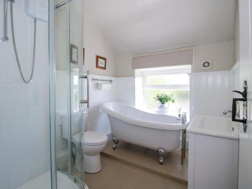 ein Badezimmer mit Badewanne, Toilette und Waschbecken in der Unterkunft Pennal Cottage in Oswestry