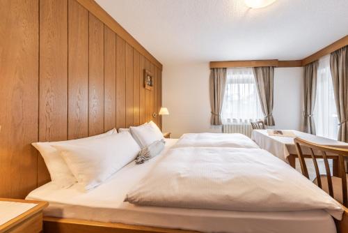 コルヴァーラ・イン・バディーアにあるVilla Resi B&Bの木製のヘッドボードが付いた大きなベッドのある寝室