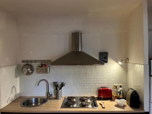 une cuisine avec un évier et une cuisinière four supérieur dans l'établissement Appartement dans le centre historique superbe vue, à Aix-en-Provence