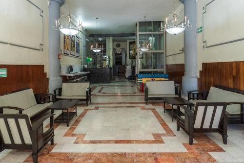 a hallway with chairs and tables in a building at Capital O Nueva York, Guadalajara centro downtown in Guadalajara