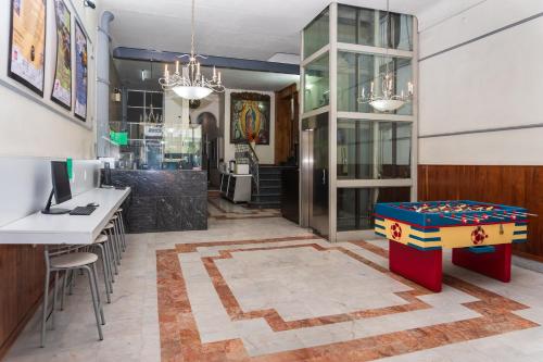 a lobby of a restaurant with a table and chairs at Capital O Nueva York, Guadalajara centro downtown in Guadalajara