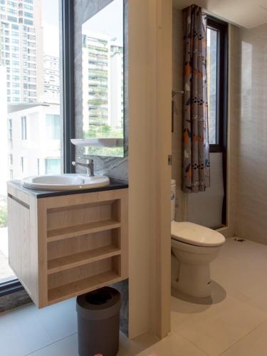 a bathroom with a sink and a toilet and a window at Shizuka House - 500 m walk to BTS Phrom Phong in Bangkok