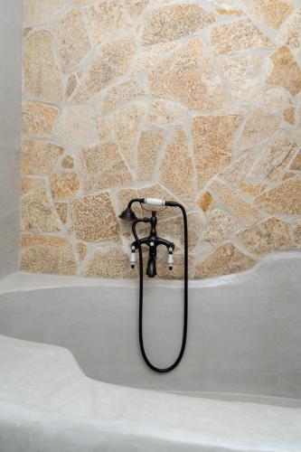 a bath tub with a hose attached to a stone wall at Villa Hyacinth by A&D Properties in Porto Rafti