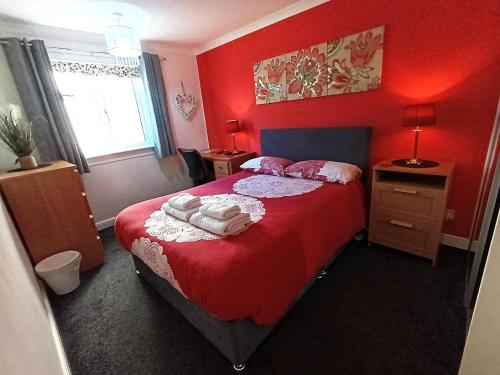 a red bedroom with a bed with red walls at Double room in riverside apartment in Glasgow