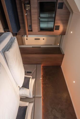 a small bedroom with a bed and a tv on the wall at Innspire Hotel in Munich