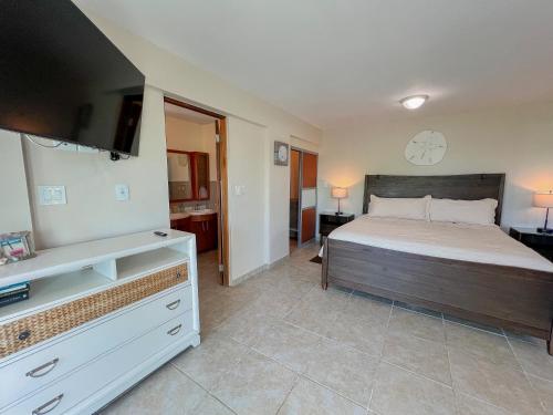 a bedroom with a bed and a flat screen tv at Island Charm Culebra - Studios & Suites - Amazing Water views in Culebra Puerto Rico! in Culebra