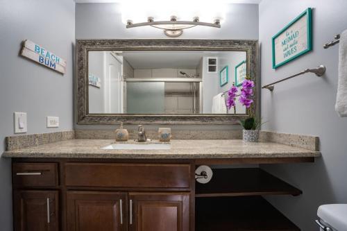 a bathroom with a sink and a mirror at Kahana Reef 120 by Coldwell Banker Island Vacations in Kahana