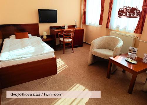 a hotel room with a bed and a desk and a chair at Hotel Podhradie in Považská Bystrica