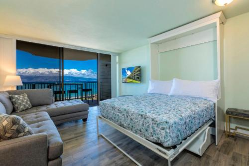 a bedroom with a bed and a couch at Kahana Reef 205 by Coldwell Banker Island Vacations in Kahana