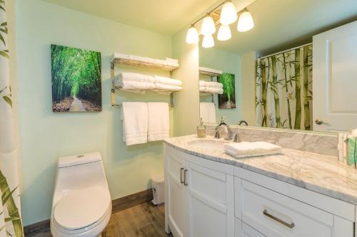 a bathroom with a toilet and a sink and a mirror at Kahana Reef 205 by Coldwell Banker Island Vacations in Kahana