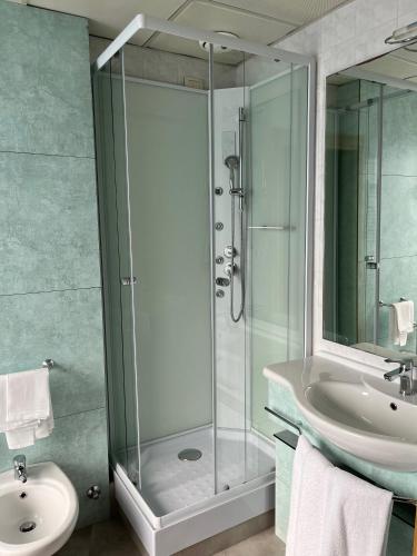 a bathroom with a glass shower and a sink at Hotel Re in Lissone