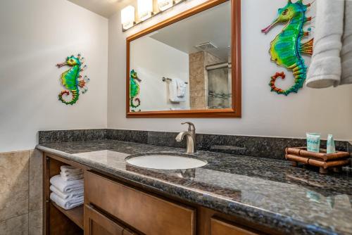 a bathroom with a sink and a mirror at Kahana Reef 305 by Coldwell Banker Island Vacations in Kahana