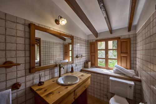 a bathroom with a sink and a mirror and a toilet at Can Busquets - Tramuntana Suite in Banyalbufar