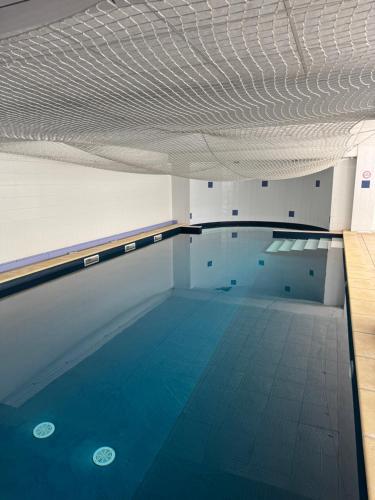 une grande piscine avec de l'eau bleue et un plafond dans l'établissement Séjour Evasion à Uzès, à Uzès