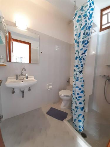 a bathroom with a sink and a toilet and a mirror at fi naxos in Agios Prokopios