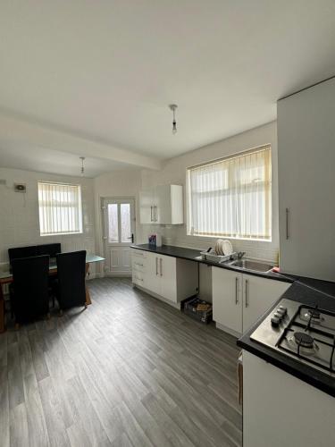 an empty kitchen with white cabinets and a table at Single bedroom 1 in Anfield in Liverpool