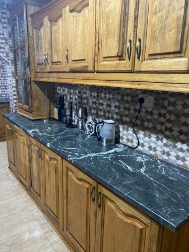 a kitchen with wooden cabinets and a green counter top at Dalal Jamu in Serekunda