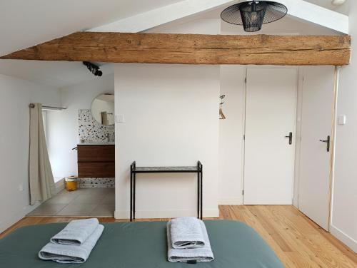a bedroom with a bed with two towels on it at Maison Irondas in Saint-Pierre-dʼAurillac