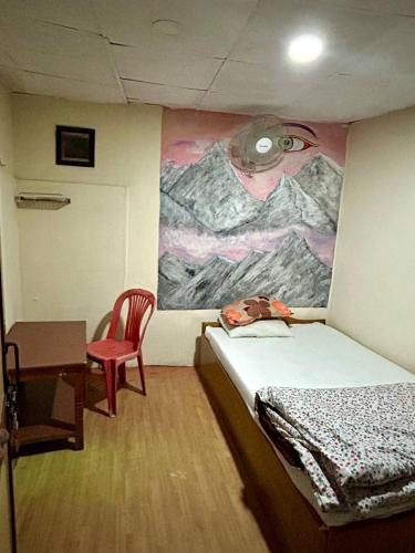 a room with a bed and a painting on the wall at Lake Forest Guest House in Pokhara