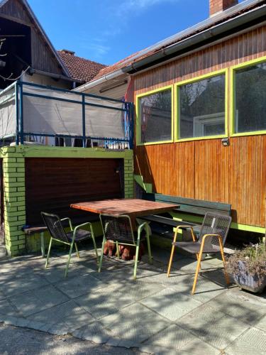 a picnic table and two chairs in front of a house at Apartment Hiža 38 in Mala Subotica